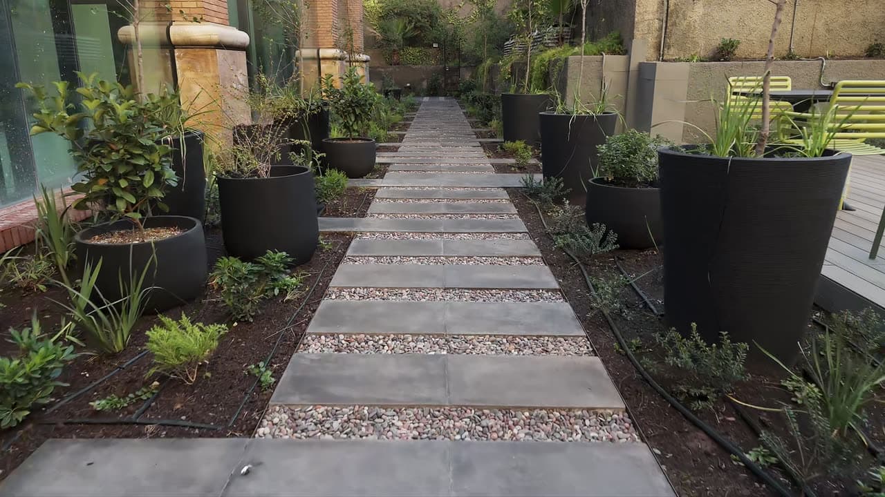Sendero de piedra y gravilla en un jardín con productos Piedras Jack