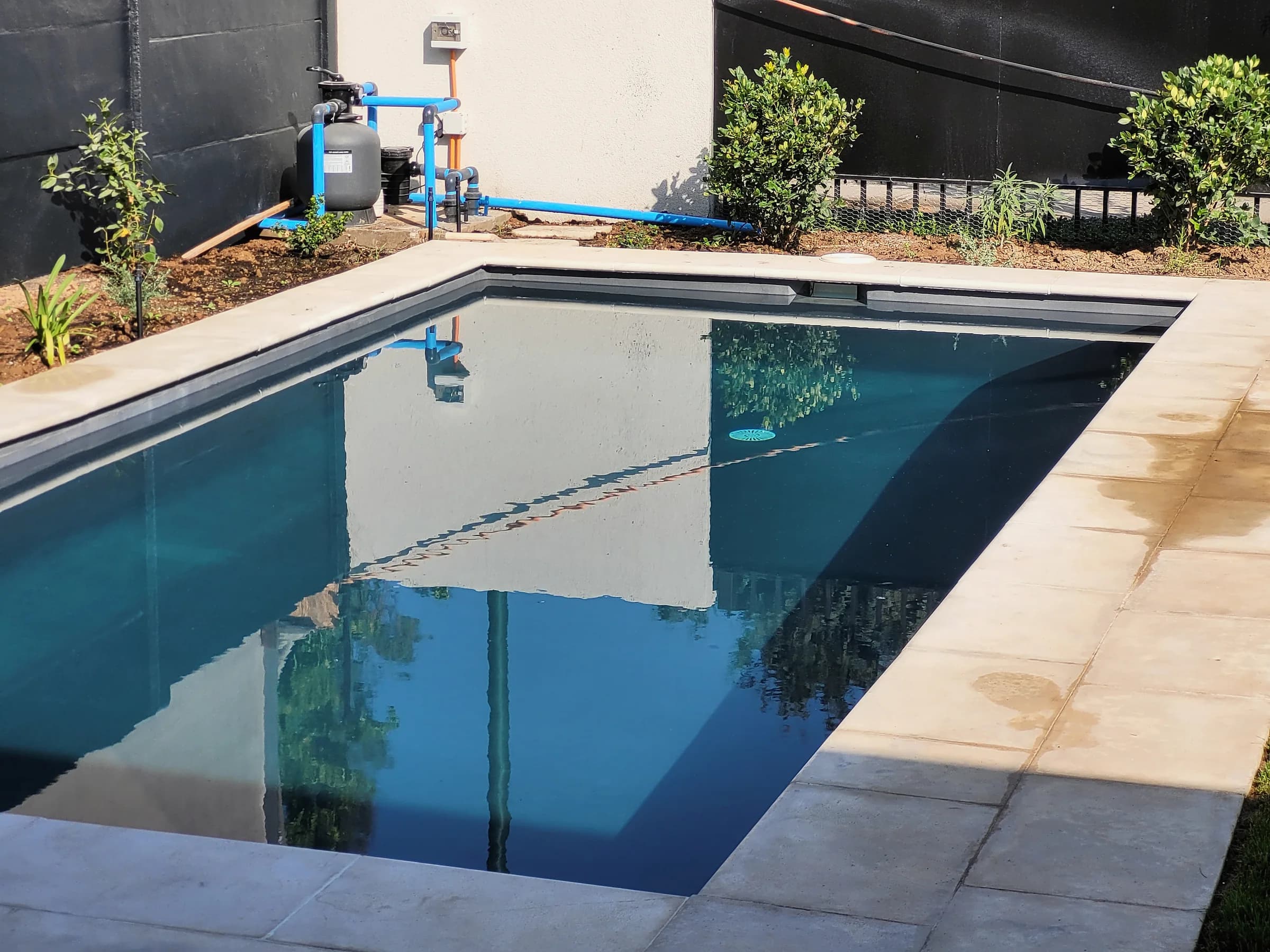 Borde rodonado y terraza instalados en torno a una piscina.